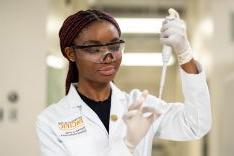 Student wearing lab coat in research lab